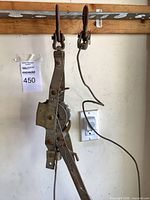 Overall view of steel hand winch hanging with hooks and cable visible