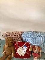 Group shot of three pillows and two plush toys