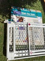 Gate and box laid on grass, full view of gate front and retail packaging