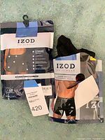 Front view of both sealed IZOD boxer brief packages showing branding, size, color