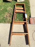 Full view of Keller wood step ladder laid flat showing steps and braces