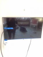 Front view of wall-mounted 32-inch LG TV with power cord