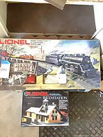 Boxed Lionel train set next to separate Rico Station kit box