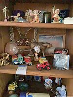 Entire lot on shelving showing die-cast vehicles, ceramic figurines and decorative objects
