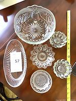 Top view of all six clear pressed and cut glass pieces displayed together