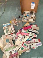 Overview of all patterns, thread spools, and packaged notions spread on floor