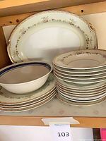 Stacked plates, bowl, platter on shelf