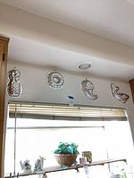 Four aluminum molds hung on wall above window
