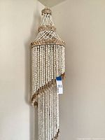Full view of shell beaded chandelier hanging from corner