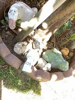 Group of concrete duck ornaments within brick edging