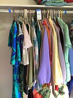 Multiple vintage garments hanging on closet rod