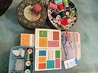 Overview of lot on table showing tin, Singer boxes and organizer