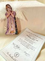 Angel ornament front view beside Certificate of Authenticity