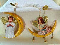 Two Bradford Exchange Magical Moonbeams ornaments hanging on display