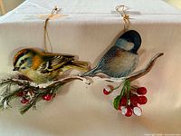Overall view of both bird ornaments showing design, hangers, and branches
