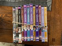 Spine view of twelve Call the Midwife DVD box sets tied together