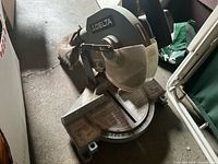Overall view of Delta 10-inch miter saw showing base, blade guard, and dust bag