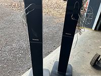 Front view of both Panasonic tower speakers with wires visible