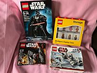 Front view of all four sealed boxes showing set titles and themes