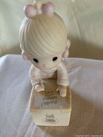 Top view of Precious Moments girl figurine writing on package