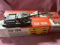 SU-100 model on its box with other boxes visible