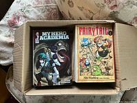 Box containing My Hero Academia volume and Fairy Tail volume
