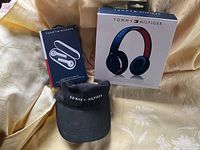Lot group shot: boxed headphones, boxed earbuds opened, black cap
