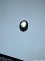 Top view of oval black star sapphire showing star effect