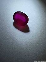 Loose oval ruby viewed from angled top showing color and transparency