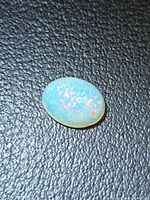 Top view of the oval opal showing multicolored pinfire