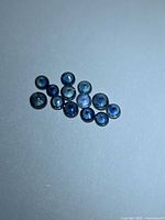 Group of 12 round blue sapphires arranged on neutral background