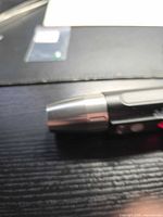 Partial view of gemological testing tool adjacent to gemstones