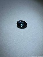 Loose oval sapphire on neutral background showing face-up color and clarity