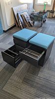 Two rolling file cabinets with drawers open showing interiors and blue cushions
