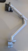 Monitor arm mounted on table showing full articulation