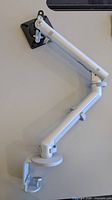 Full view of articulated monitor arm mounted on surface