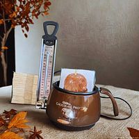 Group shot of chocolate melter, thermometer, paper cups, popsicle sticks