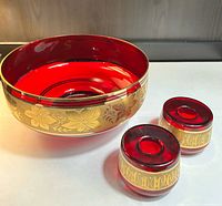 overview of ruby red pedestal bowl and two candle holders