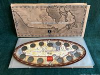 Front view showing oval holder with 12 coins and outer sleeve