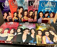 Front view of all eight Charmed DVD season box sets