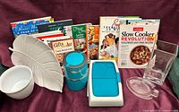 Lot overview showing cookbooks, Bento containers, leaf tray, bowl, vase and fish dish