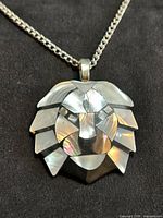Close-up of mother of pearl lion pendant on chain