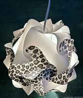 Sculptural lamp lit, showing white and leopard panels