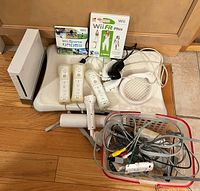 Group shot of console, balance board, controllers, games, cables