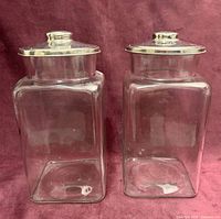 Front view of both clear glass jars with metal lids