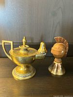 Oil lamp and bell side by side showing size and design