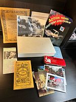 Group shot of all items laid out including bin, publications, tin, postcards, photos