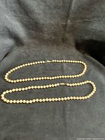 Two faux pearl necklaces laid flat to show overall appearance