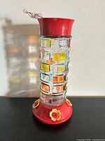 full view of glass hummingbird feeder standing upright