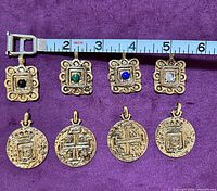 Front view of all eight pendants under measuring tape